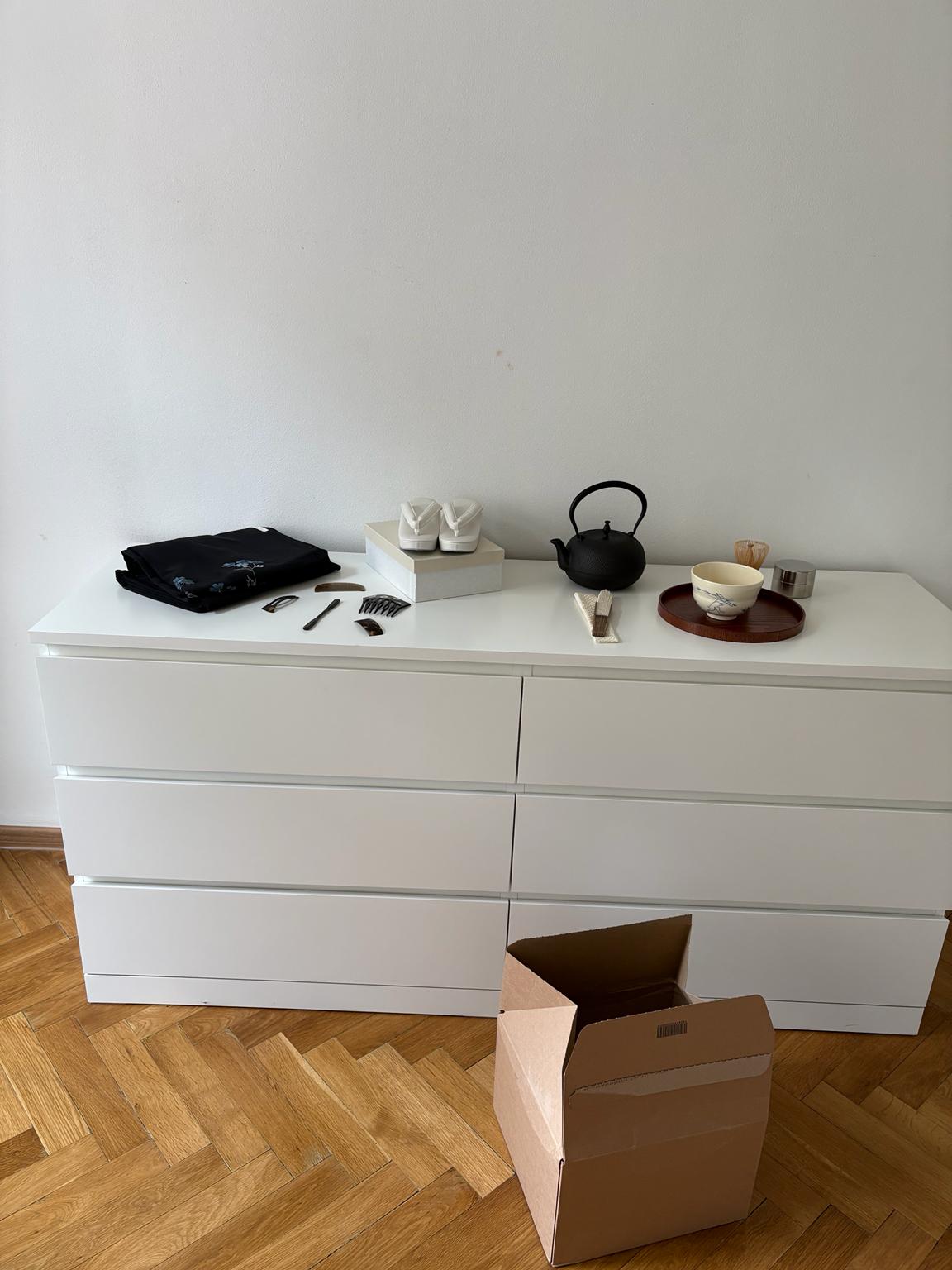 Kimono, tea utensils and traditional footwear arranged on a white cabinet