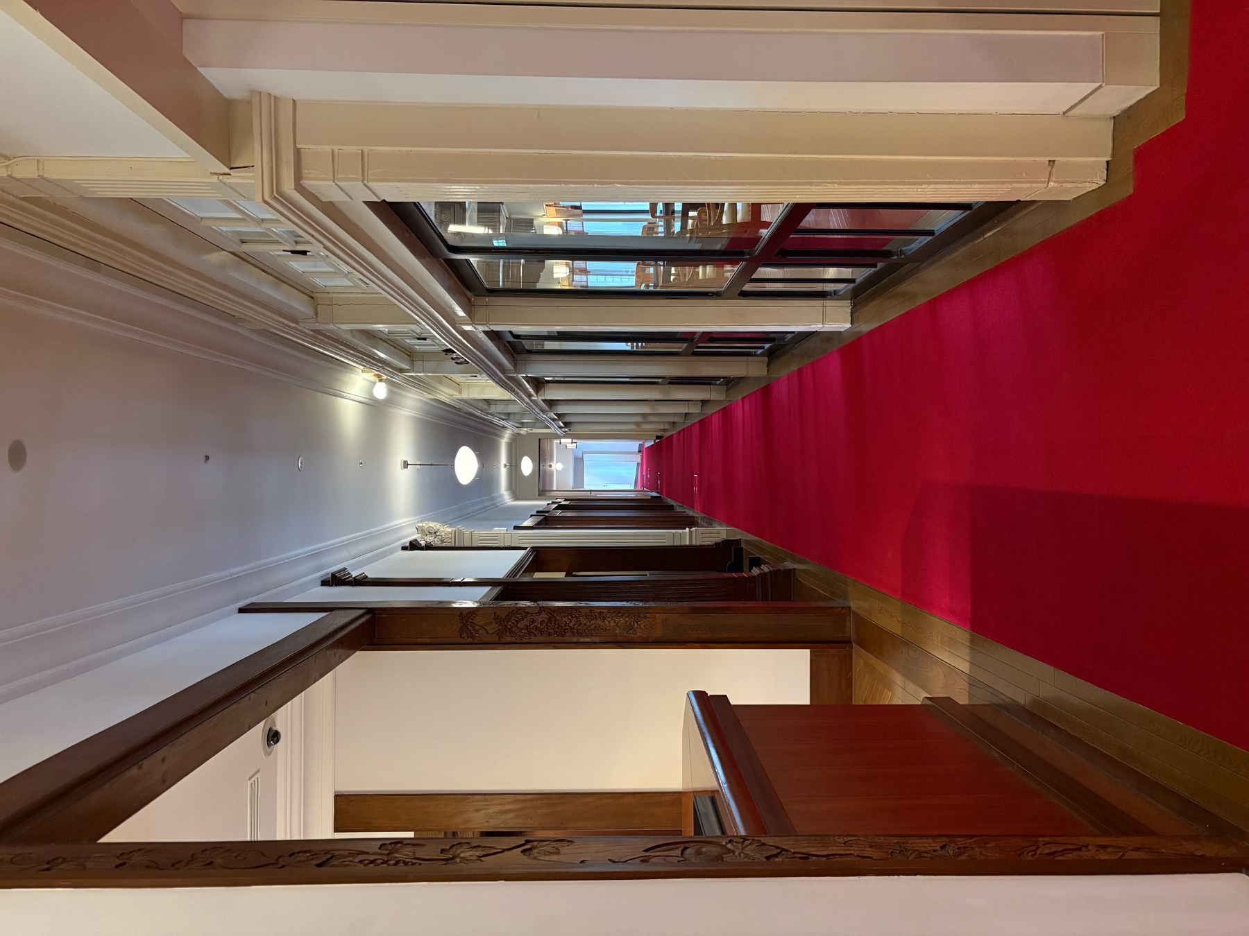 A red-carpeted hallway in a historic interior, prepared as a place for cultural encounters