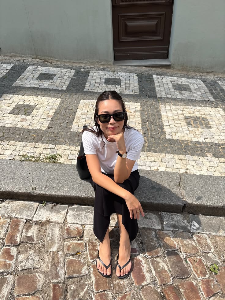 Woman sitting on a cobblestone street in Prague